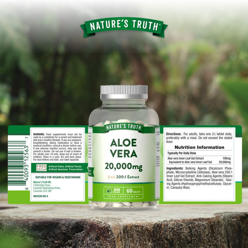 A hand holds many white round Nature's Truth Aloe Vera 20,000mg vegan tablets.