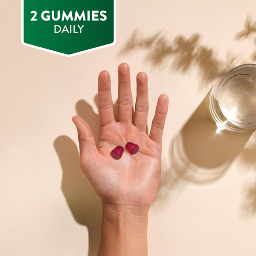 A hand holding two red NU Omega 369 & Multivitamin Vegetarian Gummies with text stating '2 GUMMIES DAILY'.
