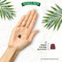 A hand holding a dark red, bell-shaped vegan gummy with text 'Vegan friendly gummies' and 'NATURE'S TRUTH®'.