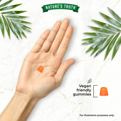 An orange gummy lies in an open hand, with another gummy beside the text 'Vegan friendly gummies'.