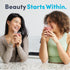 Two young adult women smiling and holding red drinks with Collagen Complex.