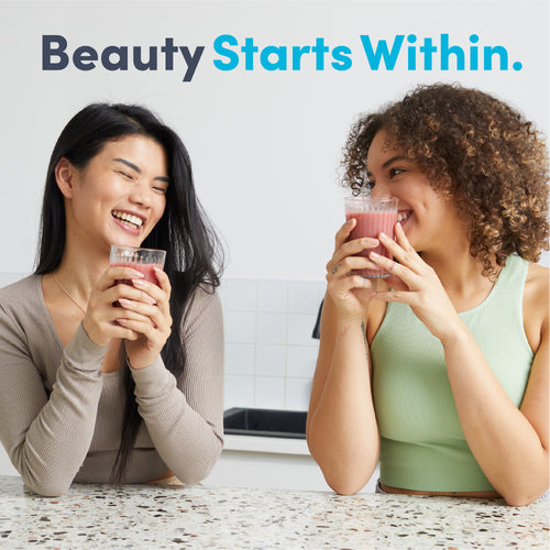 Two young adult women smiling and holding red drinks with Collagen Complex.