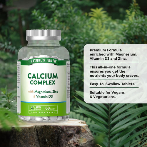 Hand holding Natures Truth Calcium Complex bottle with 60 white tablets visible.