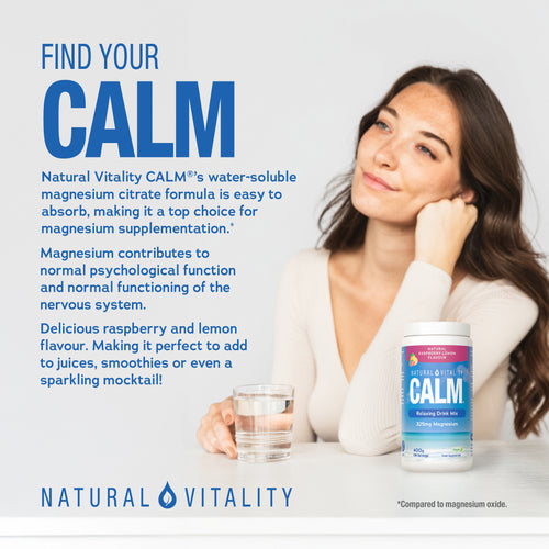 A young woman holds a glass of water thoughtfully, with a tub of Natural Vitality Calm on a white table.