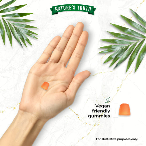 A hand holds an orange gummy near the words 'Vegan friendly gummies' and another orange gummy.